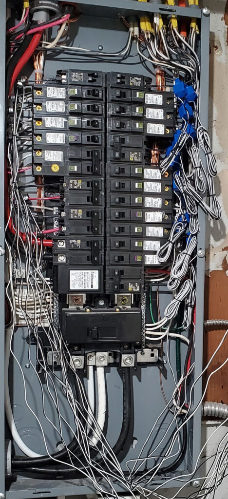 A photograph of the inside of the breaker box with CTs attached to each circuit wire.